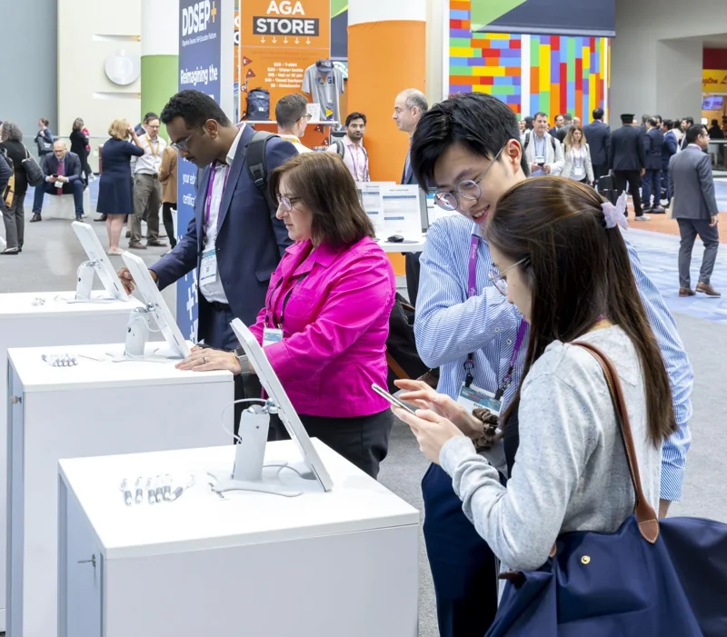 Attendees gathered around an exhibition demonstration
