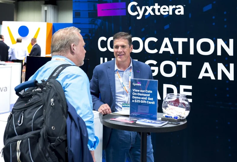 Attendees talking at a branded exhibition counter
