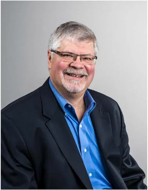 Corporate headshot on a plain white or gray background, selection 1