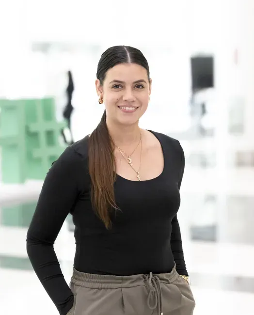 Corporate headshot of a woman in a black top against a softly blurred light background