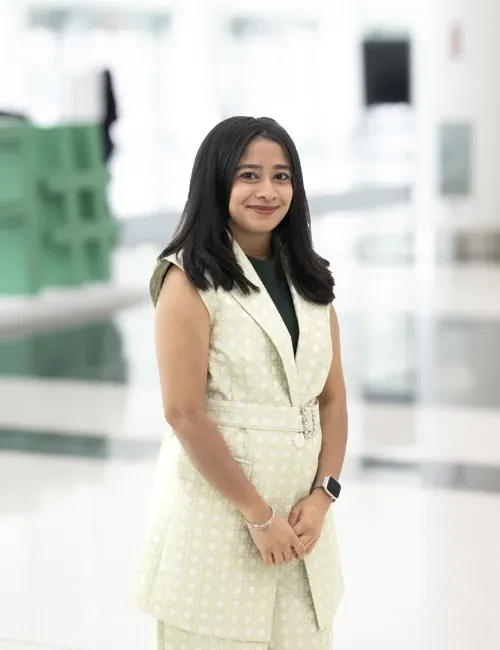 Corporate headshot of a woman in a light dress against the matching green-and-white FIME background