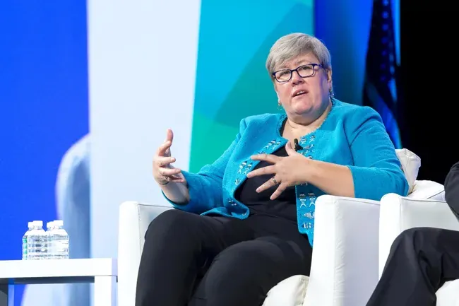 World Gas Conference — Panel speaker gesturing against a bright blue and green backdrop