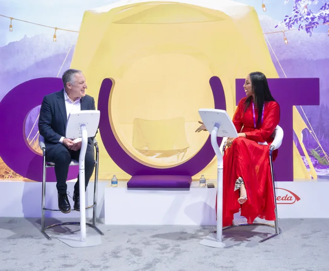 Two attendees trying interactive devices at a colorful exhibition booth
